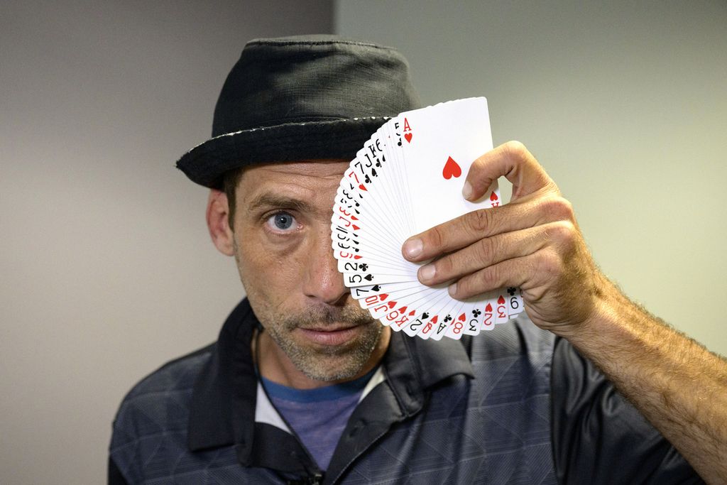 Paul Carpenter, pesulap jalanan asal New Orleans, Amerika Serikat, memainkan gerak tipuan dengan kartu dalam sebuah wawancara di New Orleans, AS, Jumat (23/2/2024). 