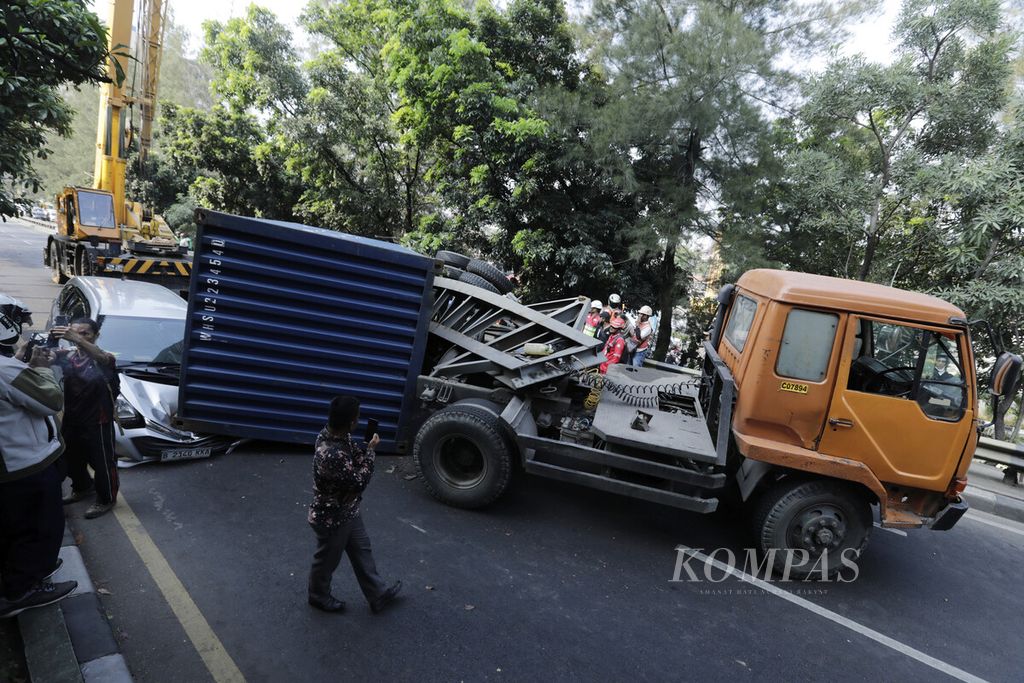 Sebuah minibus Daihatsu Sigra tertimpa kontainer truk bermuatan granit yang terguling di jembatan layang Ahmad Yani, Kota Bekasi, Jawa Barat, Sabtu (4/5/2024). Tidak ada korban jiwa dalam kecelakaan tersebut. Posisi kendaraan yang melintang menghalangi arus lalu lintas dan menimbulkan kemacetan panjang karena pengalihan arus kendaraan menuju jembatan layang arah ke Rawa Panjang tersebut. 