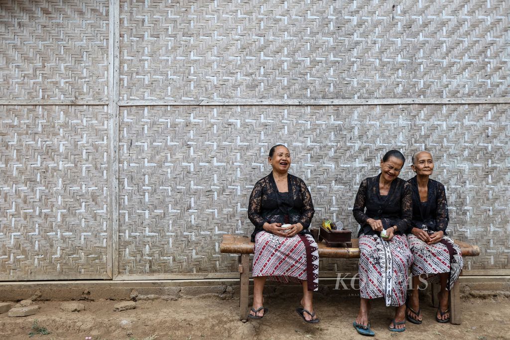 Tiga perempuan lanjut usia duduk di depan salah satu rumah di Desa Kemiren, Kabupaten Banyuwangi, Jawa Timur, Jumat (17/11/2023). Perempuan sepuh memiliki peran penting sebagai penjaga pengetahuan tentang makanan dan ritual di Desa Kemiren.