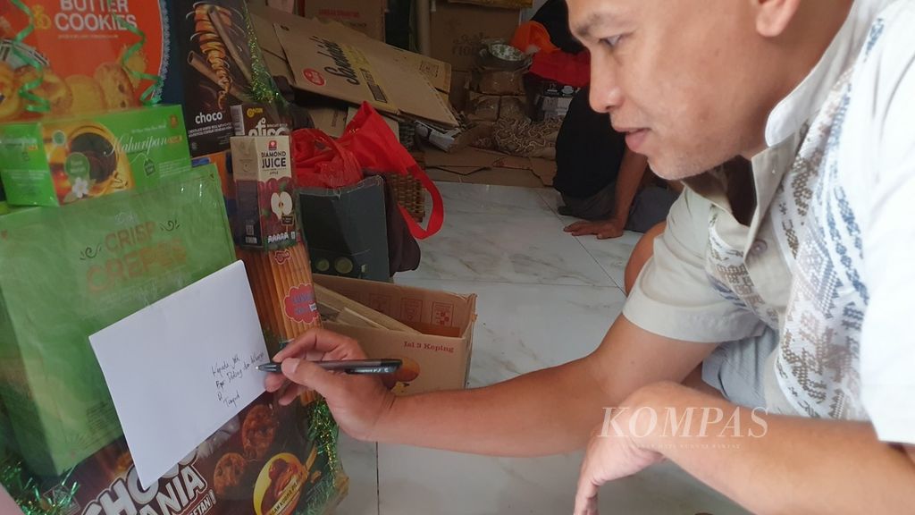 Pengusaha parsel menuliskan alamat di parsel yang baru selesai mereka rangkai dan siap untuk dikirim ke pemesan, Cikini, Jakarta Pusat, Selasa (26/3/2024).