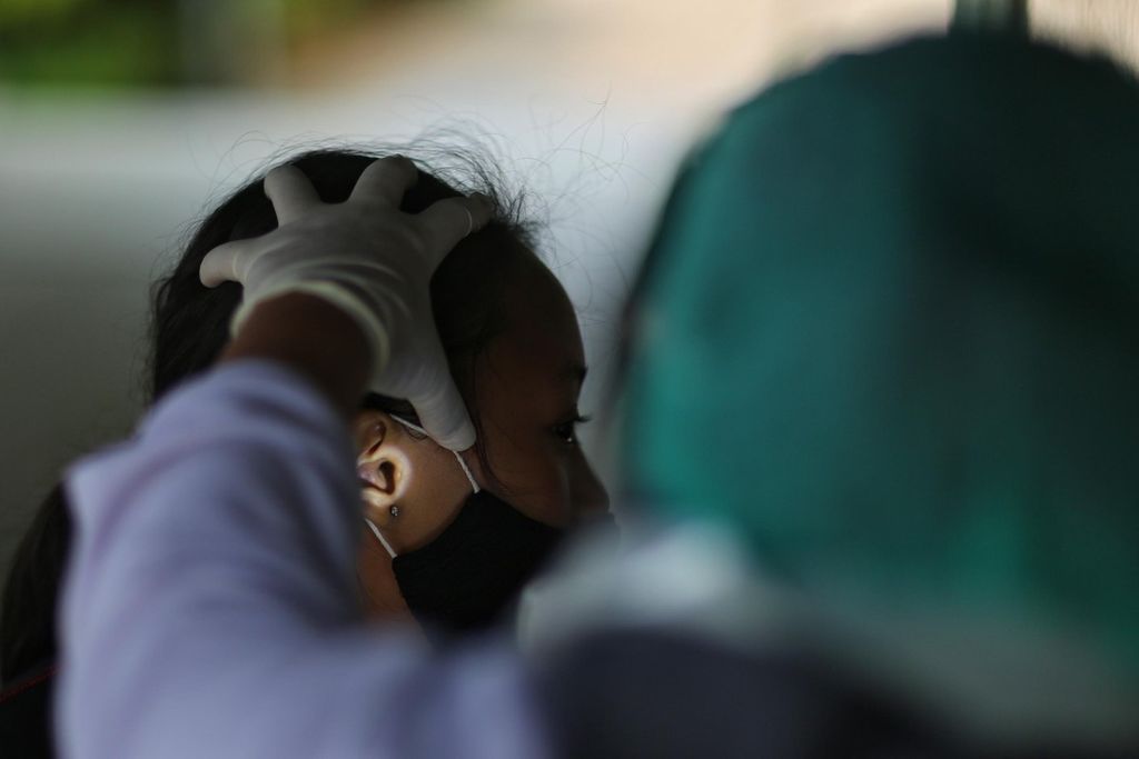 Seorang pelajar diperiksa kebersihan telinganya saat mengikuti imunisasi diphteria tetanus (Dt) yang diadakan oleh Puskesmas Rawa Bunga, Jatinegara, Jakarta Timur, Rabu (29/9/2021). 