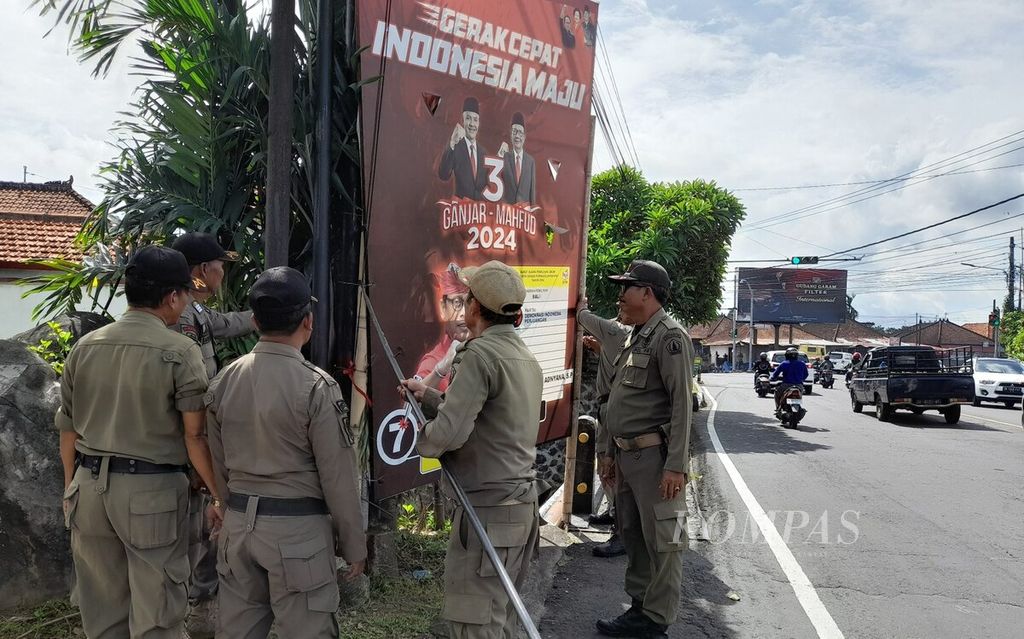 Tim gabungan dari KPU Kabupaten Badung, Bawaslu Kabupaten Badung, dan Satpol PP Pemerintah Kabupaten Badung, Bali, Senin (12/2/2024), menurunkan alat peraga kampanye yang masih terpasang di wilayah tersebut. 