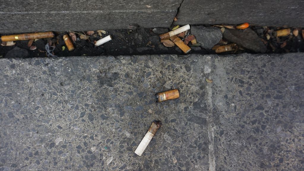 Puntung rokok yang terbuang begitu saja di salah satu sudut trotoar kawasan Malioboro, di Yogyakarta, Minggu (24/11/2019). Minggu itu, Komunitas Global No Cigarettes Movement menggelar aksi mengumpulkan puntung rokok yang terbuang sembarangan di sana. Hasilnya, diperoleh hampir 9.000 puntung rokok.