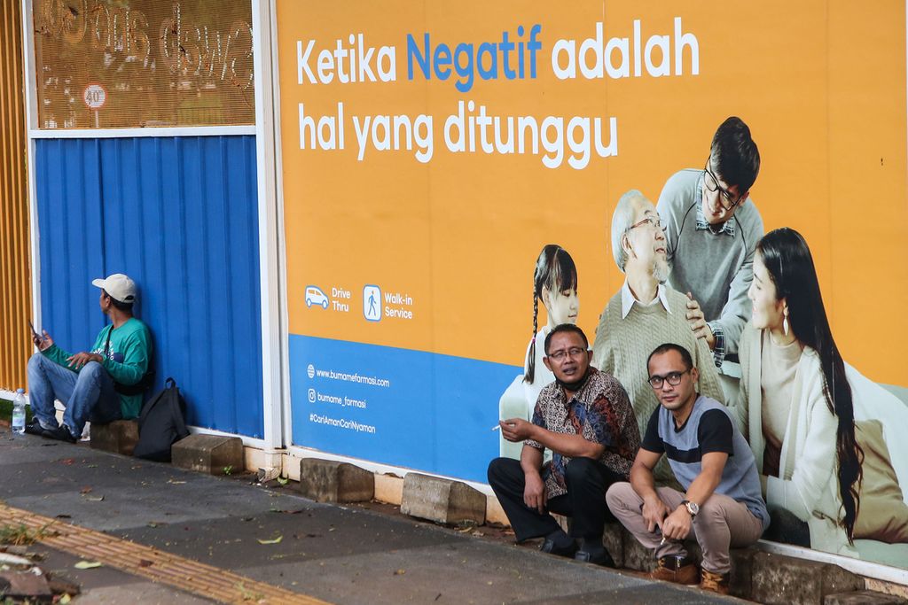 Warga beristirahat di dekat laboratorium farmasi layanan tanpa turun tes usap Covid-19 di kawasan Senayan, Jakarta, Rabu (15/6/2022). 