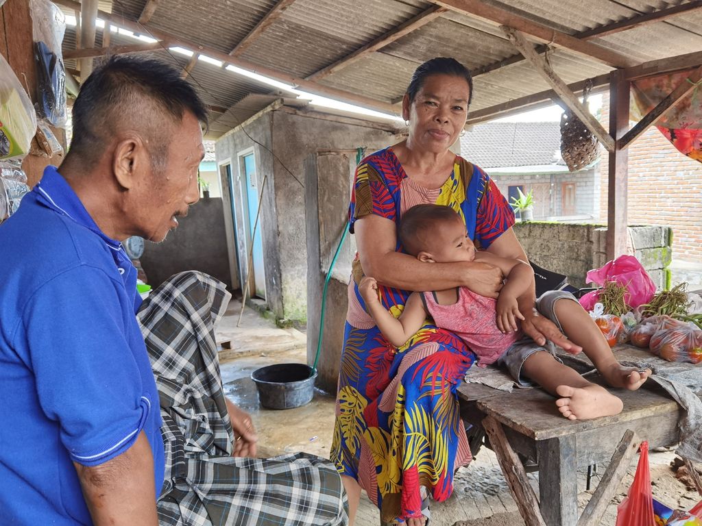 Bariah (50) dan Rustim (60) menemani cucu mereka Farizi (2) di Dusun Mungkik, Desa Pandan Wangi, Kecamatan Jerowaru, Kabupaten Lombok Timur, Nusa Tenggara Barat, Rabu (3/3/2021). Pasangan itu saat ini harus merawat empat cucu yang kedua orangtuanya menjadi pekerja migran.