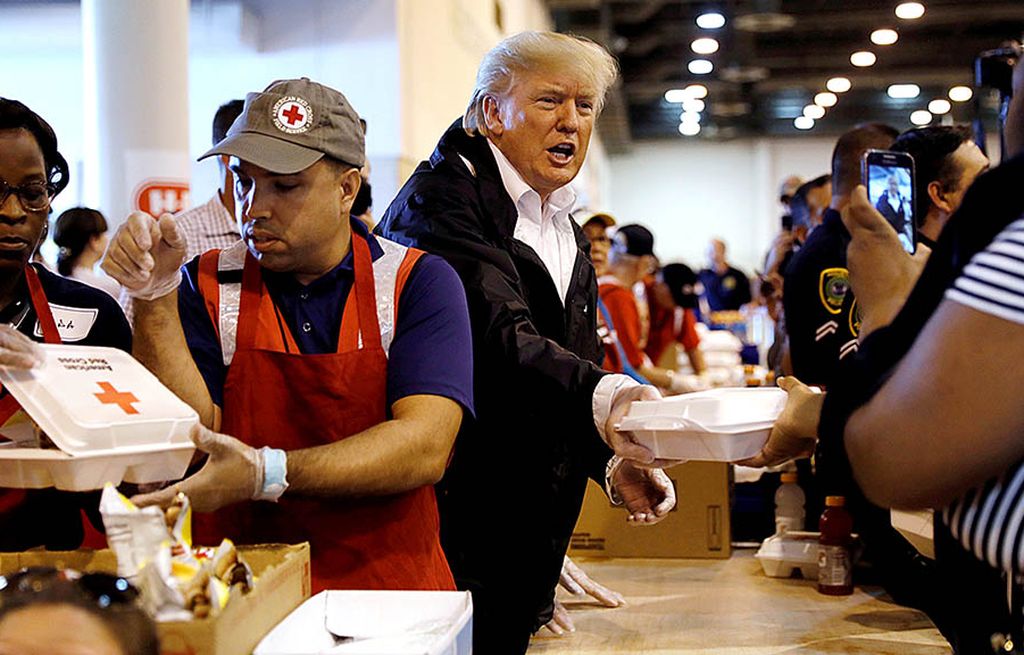 Presiden Amerika Serikat   Donald Trump turut membagikan paket makanan bagi para pengungsi saat mengunjungi pusat penampungan korban banjir akibat topan Harvey di Houston, Texas, AS, Sabtu (2/9). 