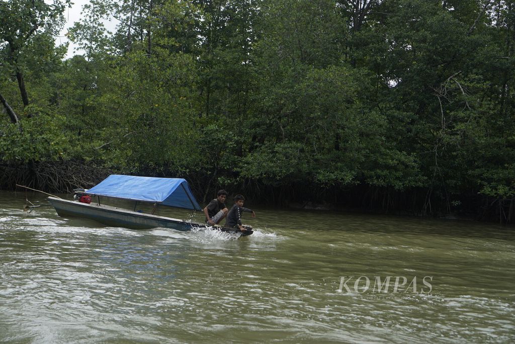 Perahu nelayan melintas di antara hutan mangrove di Teluk Balikpapan, Kalimantan Timur, Minggu (11/9/2022).