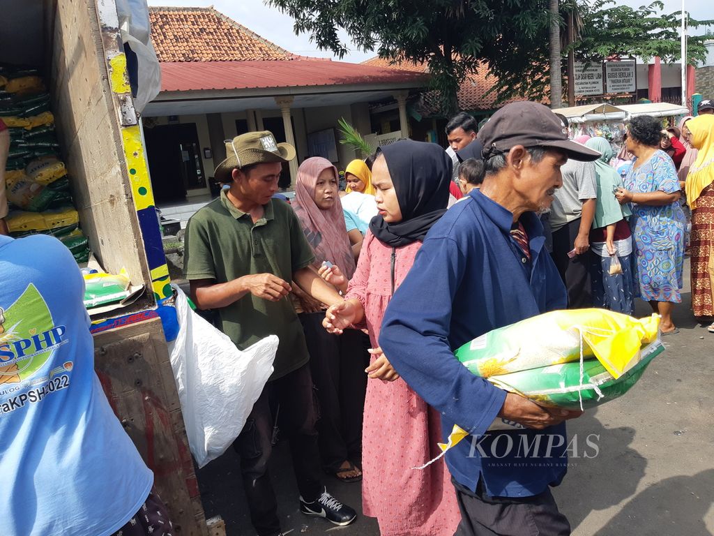 Warga mengantre membeli beras dalam operasi pasar murah di Balai Desa Lurah, Kecamatan Plumbon, Kabupaten Cirebon, Jawa Barat, Senin (26/2/2024). Di pasar murah itu, warga dapat membeli beras medium seharga Rp 52.000 per kemasan 5 kilogram. 