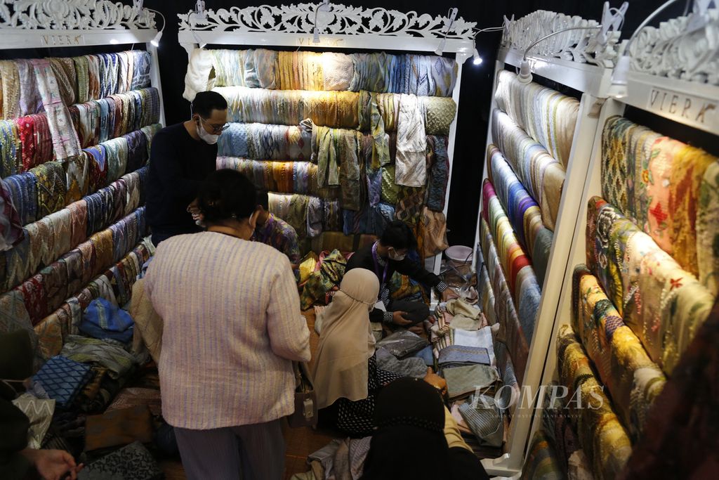 Pengunjung memilih kain batik yang dipamerkan di salah satu stan peserta Katumbiri Expo 2022 di Jakarta Convention Center, Rabu (16/11/2022). Pameran menampilkan keanekaragaman kerajinan Nusantara, seperti batik, tenun, mutiara, dan perhiasan.