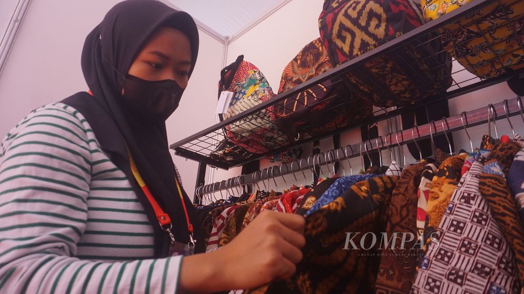 Seorang karyawan dari Batik Kalimataya mengecek kondisi kemeja batik yang dipajang dalam pameran, di Stadion Manahan, Kota Surakarta, Jawa Tengah, Sabtu (30/7/2022). Bisnis tersebut masih berskala UMKM. Optimalisasi pemasaran dilakukan secara digital untuk memperluas jangkauan pasar.