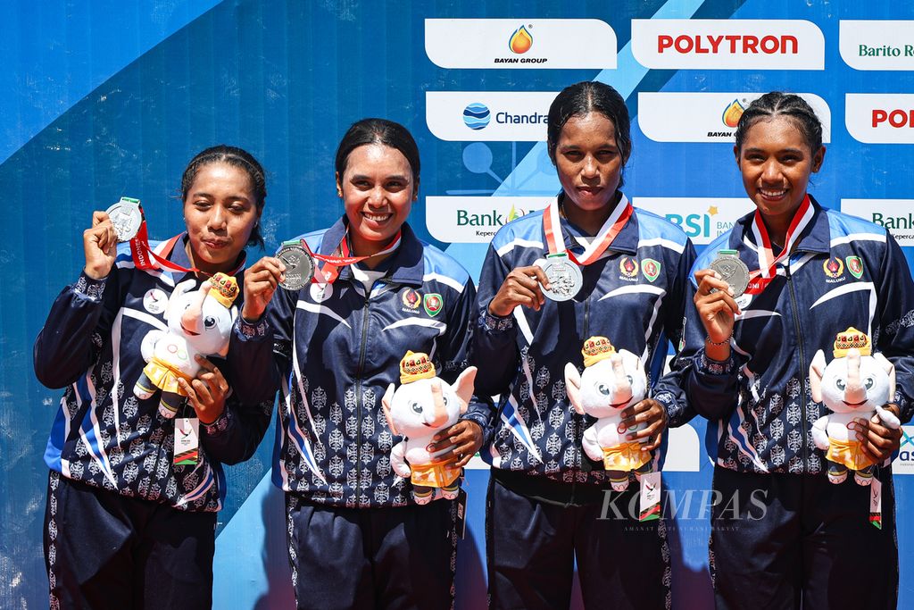 Atlet dayung Maluku, Issa Behuku (kanan), bersama timnya, menerima medali perak cabang dayung rowing nomor quadruple sculls dalam PON Aceh-Sumut 2024 di Waduk Keuliling, Aceh, Besar, Kamis (12/9/2024). 