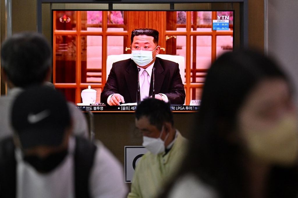 Orang-orang duduk di dekat layar monitor televisi yang menyiarkan berita di stasiun kereta api di Seoul pada Kamis (12/5/2022), tentang pemimpin Korea Utara Kim Jong Un. Kim Jong Un muncul di televisi dengan memakai masker untuk pertama kalinya. Dia memerintahkan penguncian nasional setelah Korea Utara mengkonfirmasi  kasus Covid-19 pertama.