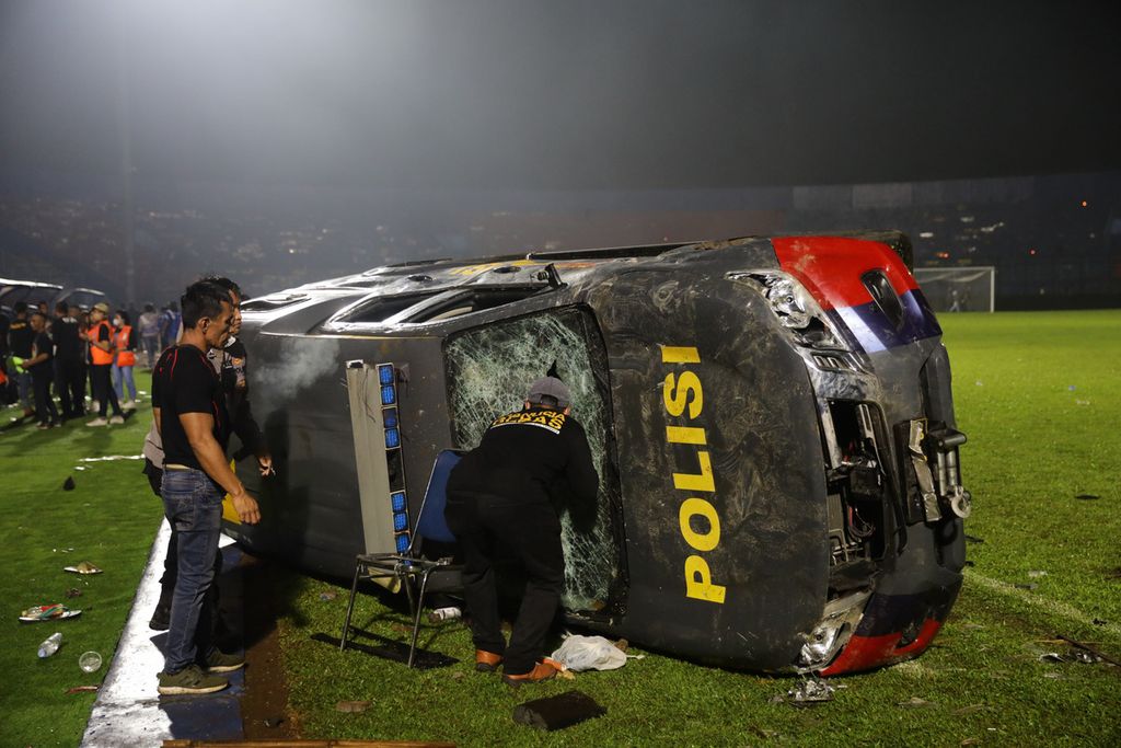 Sebuah mobil polisi terbalik akibat kericuhan usai pertandingan BRI Liga 1 antara Arema melawan Persebaya di Stadion Kanjuruhan, Malang, Jatim, Minggu (2/10/2022). Sebanyak 127 orang dilaporkan meninggal dunia dalam kerusuhan tersebut.
