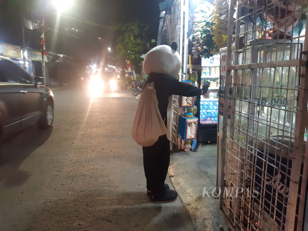 Sandor (26), badut asal Kebayoran, Jakarta Selatan, saat menghibur warga di salah satu warung di Jaln Palem Utama, Palmerah, Jakarta Barat, Jumat (16/6/2022) malam.