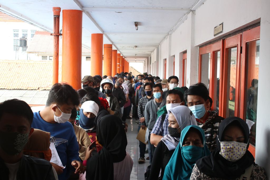 Puluhan warga mengantre untuk mengambil bantuan sosial dari Pemerintah Provinsi Jawa Barat di Kantor Pos Jalan Asia Afrika, Kota Bandung, Selasa (29/12/2020). Bantuan ini diberikan kepada 1.903.383 Keluarga Rumah Tangga Sasaran (KRTS) di pekan akhir tahun 2020.