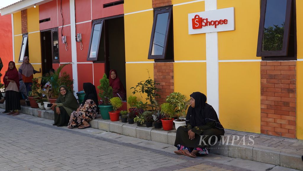 Warga duduk di depan rumah mereka yang baru saja dipugar di Kelurahan Semanggi, Kota Surakarta, Jawa Tengah, Selasa (7/2/2023).