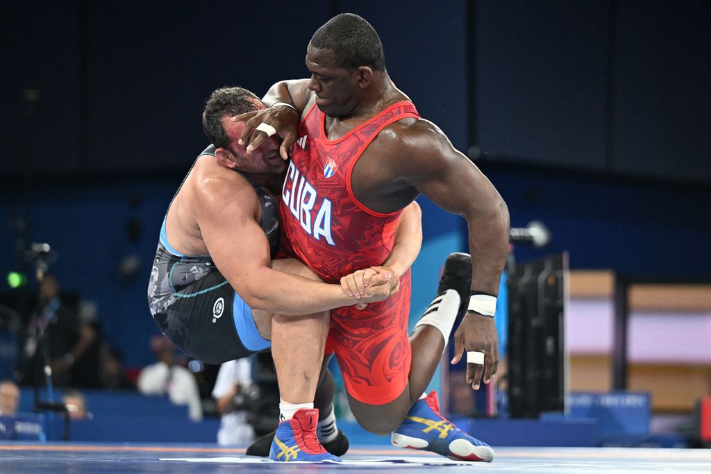 Atlet Kuba, Mijain Lopez Nunez (kanan), bertarung melawan Sabah Saleh Shariati (Azerbaijan), di semifinal nomor greco-roman 130 kilogram putra gulat Olimpiade Paris di Champ-de-Mars Arena, Paris, Perancis, 5 Agustus 2024. 