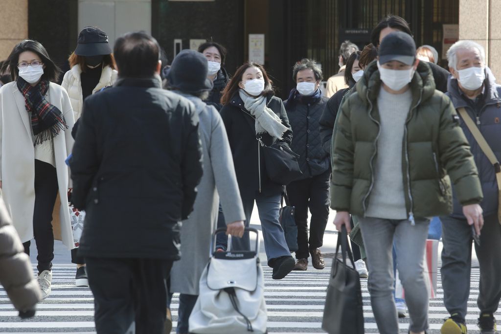 Orang-orang menggunakan masker untuk melindungi dari penyebaran virus korona di Tokyo, Jepang, awal Februari 2022.