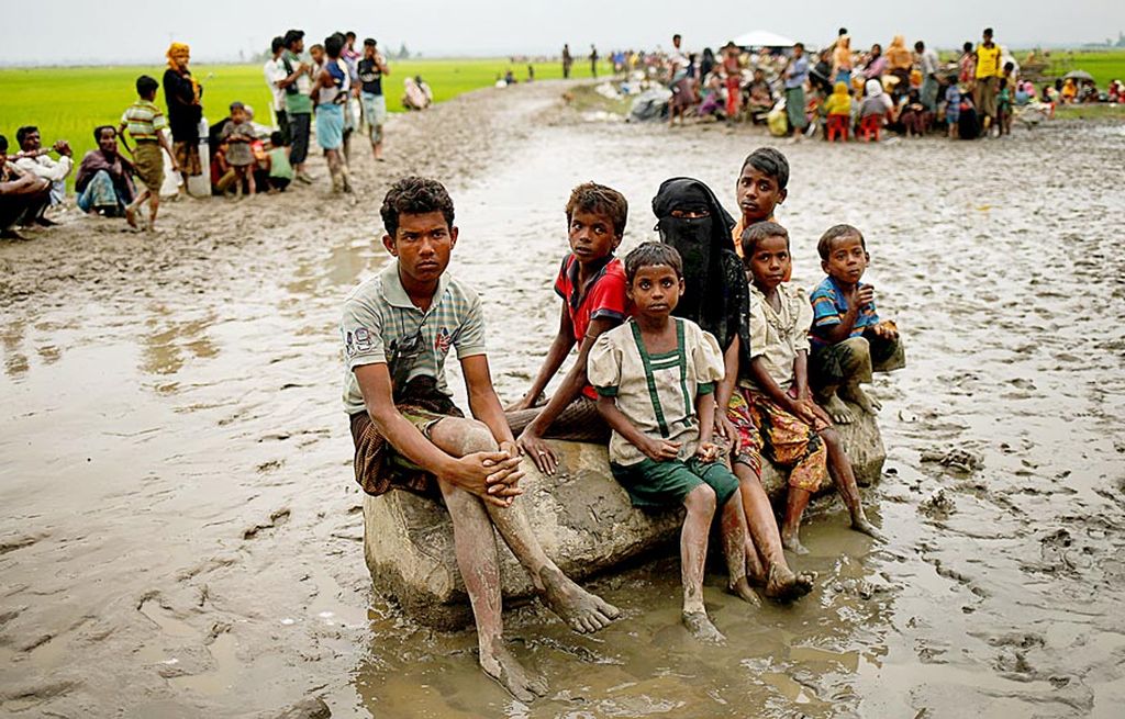 Pengungsi Rohingya menanti pemeriksaan pasukan Penjaga Perbatasan Banglades (BGB) di tempat terbuka setelah melintasi perbatasan antara Myanmar dan Banglades di Teknaf, Banglades, Minggu (3/9). 