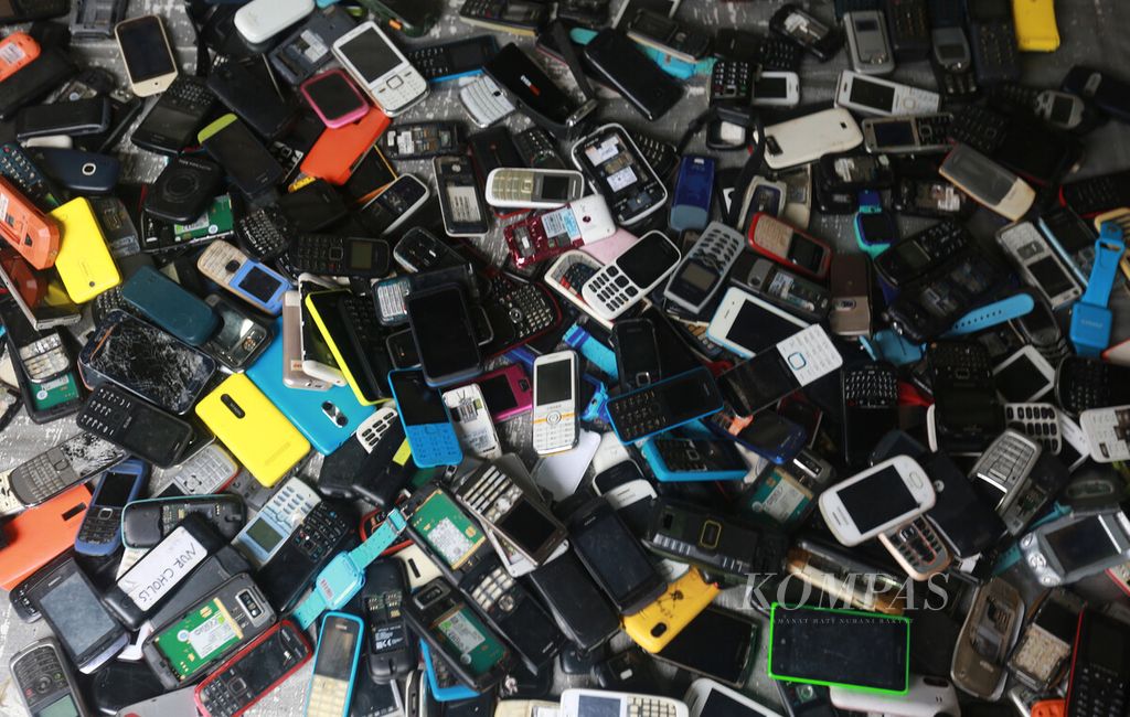 Tumpukan ponsel bekas yang digelar di salah satu lapak di pasar loak Jembatan Item, Jatinegara, Jakarta Timur, Minggu (20/2/2022). 