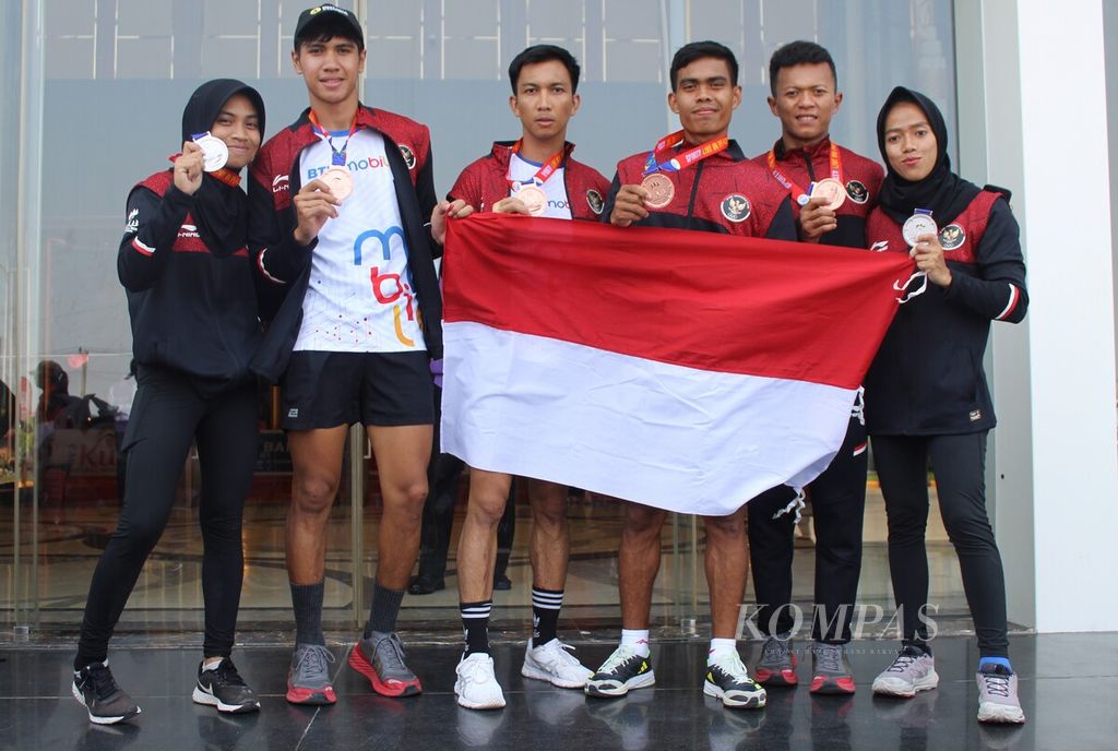 Atlet obstacle race Indonesia berpose memegang medali dan bendera Indonesia di Chroy Changvar Convention Center, Phnom Penh, Kamboja, Minggu, (7/5/2023). Mereka memiliki kisahnya masing-masing sebelum berjuang di Kamboja demi Indonesia.