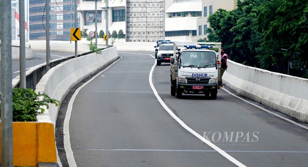 Kendaraan dinas perhubungan yang mensterilkan jalanan setelah waktu uji coba jalur sepeda di Jalan Layang Non-Tol Kampung Melayu-Tanah Abang, Jakarta, saat waktu yang diterapkan berakhir, Minggu (13/6/2021).