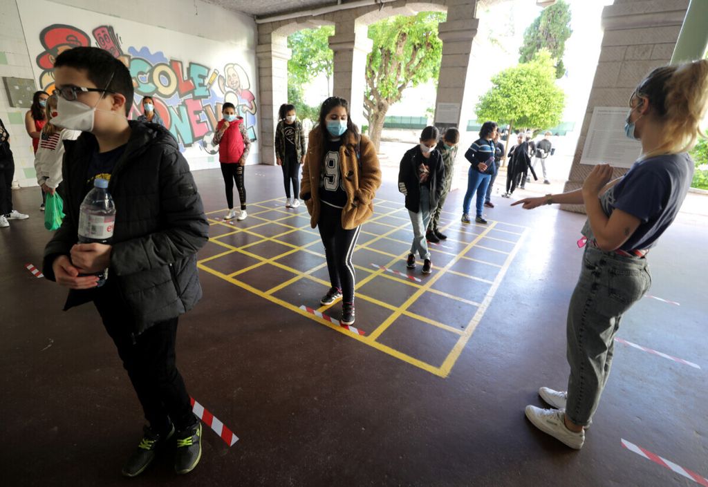 Murid-murid SD di Nice, Perancis, mengantre dan menjaga jarak setelah sekolah kembali dibuka di tengah pandemi Covid-19 pada 12 Mei 2020.