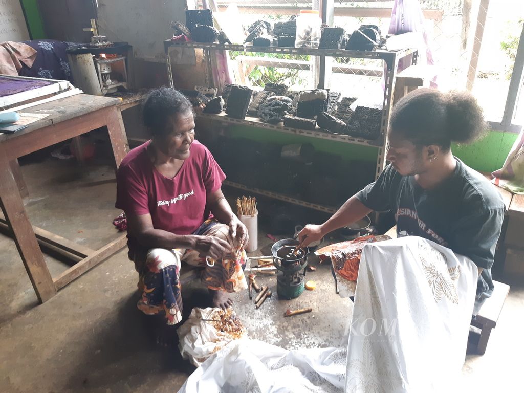 Blandina Ongge, pemilik Sanggar Batik Phokouw Faa, di Kota Jayapura, Papua, mengawasi salah seorang pekerjanya yang sedang mencanting di kain, Kamis (24/8/2023).
