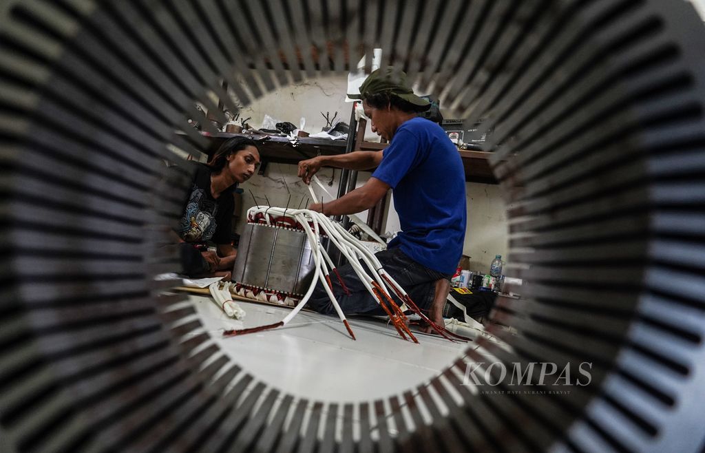 Sejumlah pekerja tengah menyelesaikan perakitan dinamo penggerak kendaraan listrik di bengkel kerja Braja Elektrik Motor, Sukolilo, Kota Surabaya, Jawa Timur, Jumat (9/9/2022). 