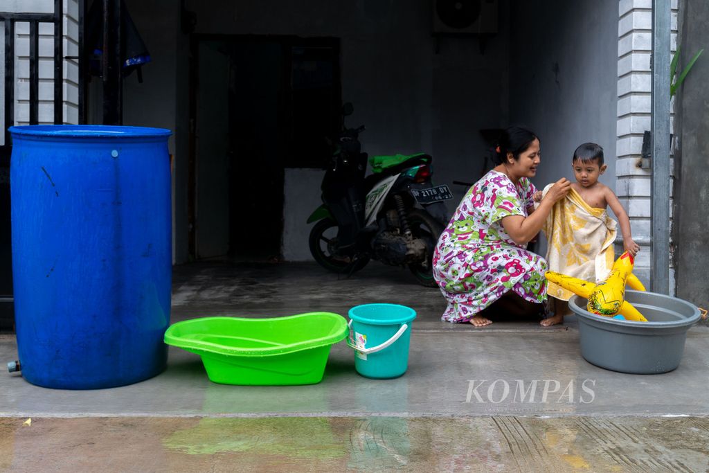 Seorang ibu memandikan anak di Perumahan Bukit Raya, Kecamatan Batam Kota, Kota Batam, Kepulauan Riau, Senin (23/1/2023). 