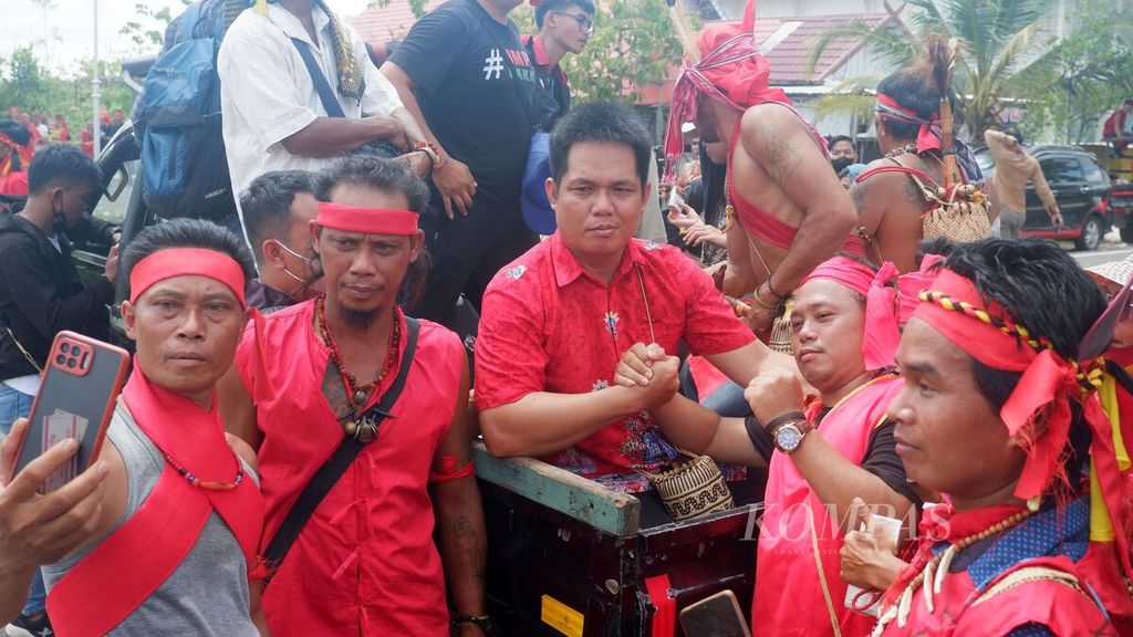 Massa aksi berfoto dengan Kepala Desa Kinipan Willem Hengki (tengah) setelah divonis bebas dalam sidang putusan kasus dugaan korupsi di Pengadilan Tindak Pidana Korupsi Palangkaraya, Kalimantan Tengah, Rabu (15/6/2022).
