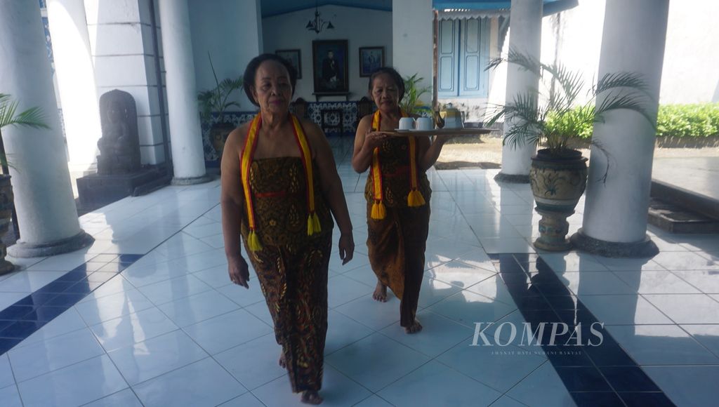 Abdi dalem membawa nampan berisikan teko, air hangat, dan teh yang akan disajikan kepada kerabat Keraton Kasunanan Surakarta di Kota Surakarta, Jawa Tengah, Rabu (17/8/2022). 
