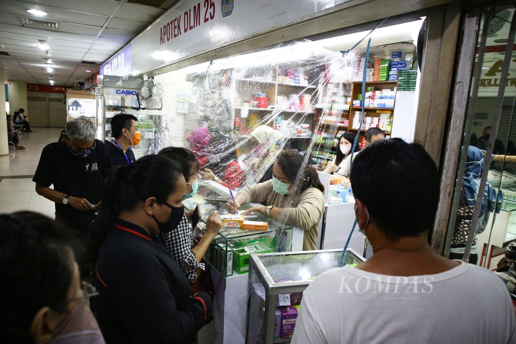 Warga berbelanja obat-obatan dari balik plastik pembatas untuk ansisipasi Covid-19 di apotek di Metro Atom Plaza Pasar Baru, Jakarta Pusat, Rabu (1/4/2020). 