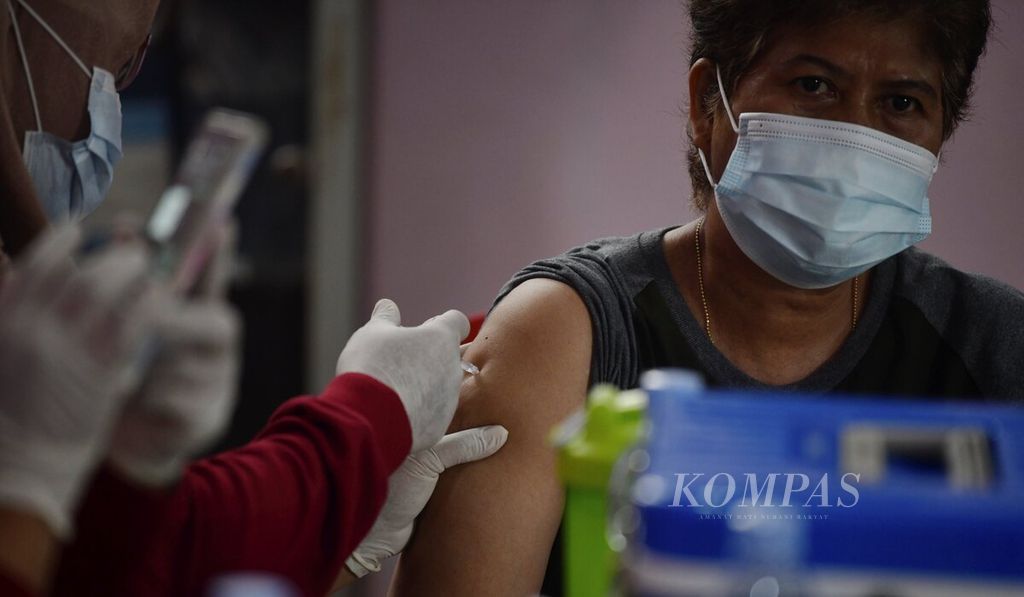 Vaksinator menyuntikan vaksin AstraZeneca kepada peserta vaksinasi Covid-19 di Kantor Kelurahan Cipondoh Indah, Cipondoh, Kota Tangerang, Banten, Senin (7/3/2022). Layanan vaksinasi dosis kedua dan vaksin penguat tersebut merupakan syarat bagi warga yang akan berbelanja minyak goreng dan daging kerbau dalam operasi pasar di lokasi yang sama.