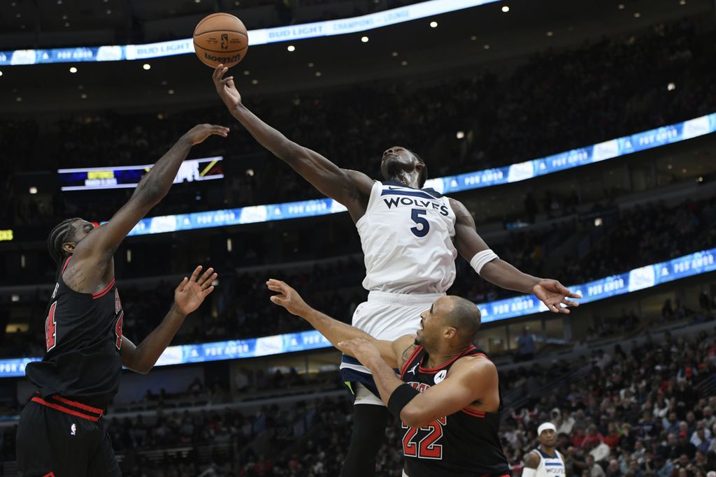 Pebasket Minnesota Timberwolves, Anthony Edwards (5), coba merebut bola <i>rebound</i> dari pebasket Chicago Bulls, Patrick William dan Talen Horton-Tucker, saat pertandingan NBA antara Timberwolves dan Bulls di Chicago, Amerika Serikat, Kamis (7/11/2024) waktu setempat. 