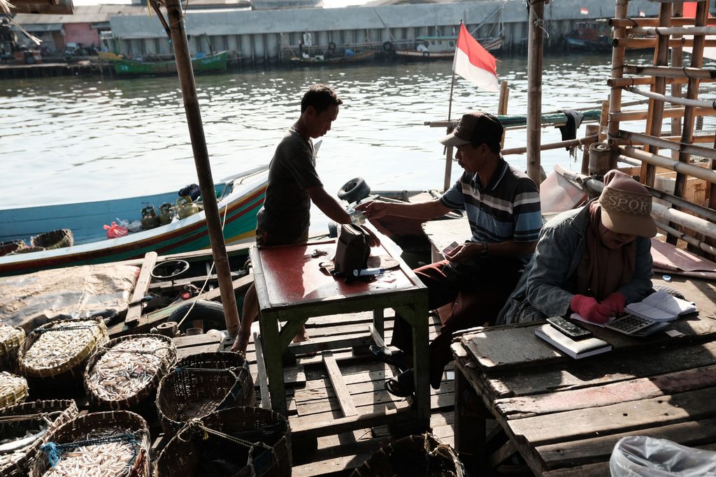 Penjual ikan mencatat hasil penjualan di Pasar Lelang Ikan, Cilincing, Jakarta Utara, Selasa (4/10/2022). 