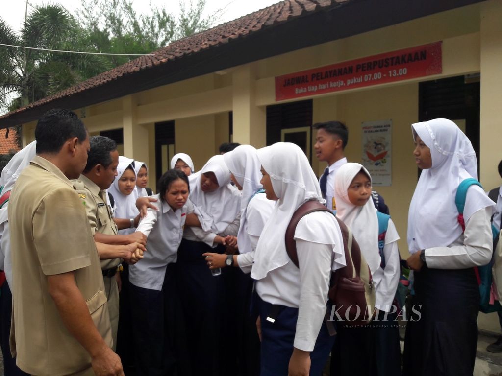 Guru dan murid mencoba menenangkan salah seorang siswi yang kesurupan di SMP N 2 Pekuncen, Banyumas, Jateng, Senin (15/1).