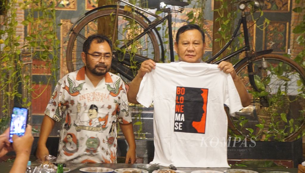 Ketua Umum Partai Gerindra Prabowo Subianto menerima kaus bergambar siluet Wali Kota Surakarta Gibran Rakabuming Raka dari sukarelawan Gibran dan Presiden Jokowi di Angkringan Omah Semar, Kota Surakarta, Jawa Tengah, Sabtu (20/5/2023). 
