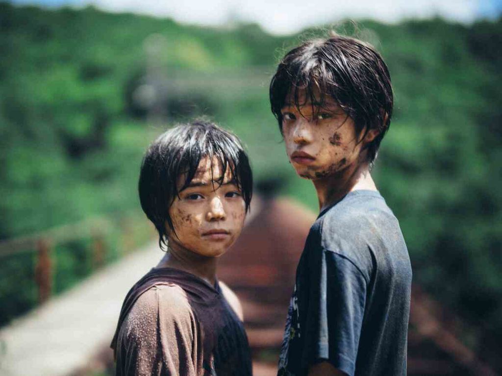 Minato dan Yori ketika bermain di tempat persembunyian mereka, terowongan gelap dan hutan, dalam film <i>Monster</i> (2023).