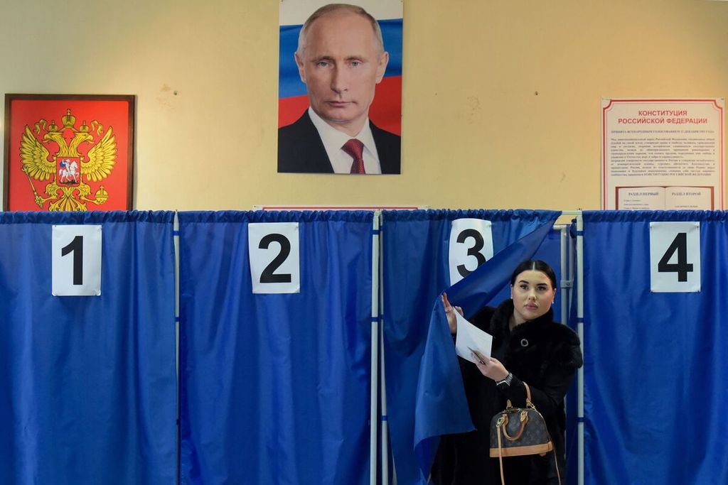 Seorang warga meninggalkan bilik suara seusai memberikan suara dalam pemilihan presiden Rusia di sebuah tempat pemungutan suara di Donetsk, wilayah Ukraina yang dikuasai Rusia, pada Sabtu (16/3/2024).