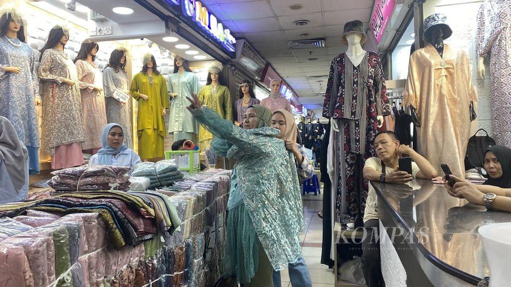 Pengunjung menjajal pakaian di Pasar Tanah Abang, Jakarta Pusat, Selasa (5/3/2024).