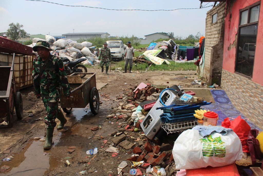 Petugas mengangkut barang-barang yang terdampak puting beliung di Desa Mangunarga, Kecamatan Cimanggung, Kabupaten Sumedang, Jawa Barat, Sabtu (24/2/2024).