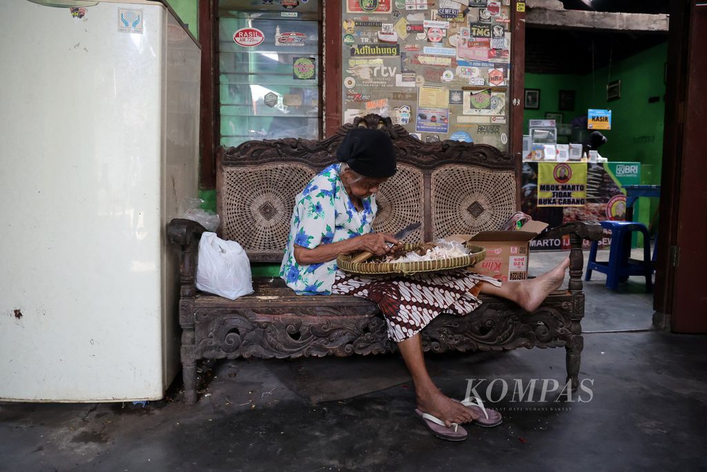 Mbah Marto (92) mengupas bahan bumbu masakan mangut lele di rumah makan Mangut Lele Dapur Asli Mbok Marto Ijoyo di Kecamatan Sewon, Kabupaten Bantul, Daerah Istimewa Yogyakarta, Rabu (21/9/2022). 