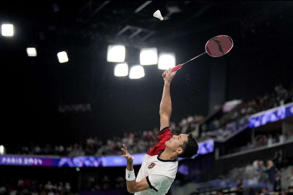 Jonatan Christie dari Indonesia bermain melawan Julien Carraggi dari Belgia dalam pertandingan penyisihan grup bulu tangkis tunggal putra mereka di Porte de la Chapelle Arena selama Olimpiade Musim Panas 2024, Sabtu (27/7/2024), di Paris, Perancis. 