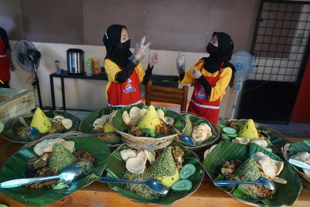 Penyandang disabilitas rungu berkomunikasi menggunakan bahasa isyarat saat menyiapkan menu makanan di Dapur Dif_able, kedai makanan di Kota Bandar Lampung, Lampung, yang dikelola oleh penyandang disabilitas, Jumat (5/3/2021).
