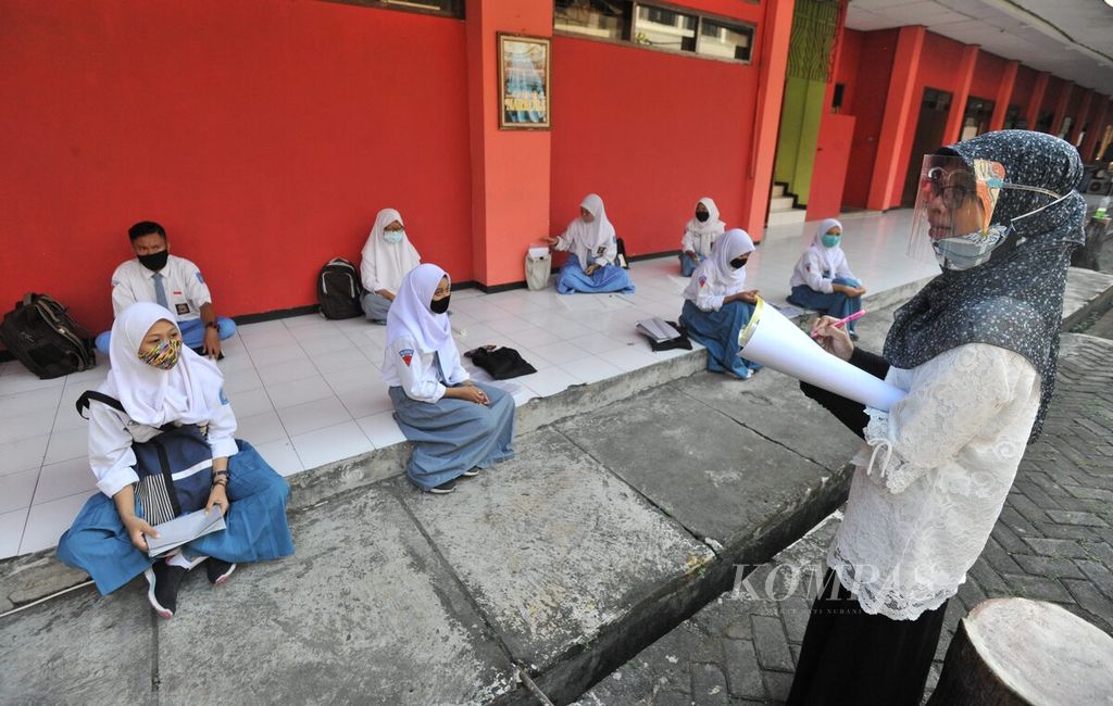 Guru mengajar siswa jurusan Kriya Tekstil SMK Negeri 12 Surabaya, Jawa Timur, Rabu (2/9/2020). Sekolah menengah kejuruan seni tersebut kembali menyelenggarakan sekolah tatap muka dan memberlakukan sistem sekolah bergilir bagi siswanya. Dalam satu hari dibagi dalam dua sif yang masing-masing hanya dihadiri oleh 300 siswa. Hal tersebut sebagai persiapan siswa kelas XI untuk magang serta persiapan tugas akhir siswa kelas XII. 