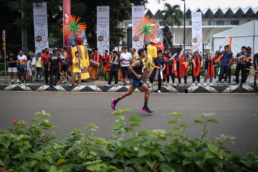 Penampilan ondel-ondel menyambut peserta yang akan mencapai garis finis dalam ajang LPS Monas Half Marathon di Istora Senayan, Jakarta, Minggu (2/7/2023). 
