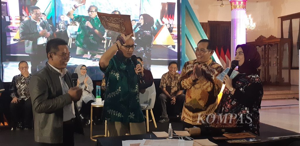 Menparekraf Sandiaga Salahudin Uno menunjukkan kulit sapi yang diukir untuk bahan produksi tas kulit di Sidoarjo, Jawa Timur, Jumat (14/7/2023) malam. Tas kulit ukir menjadi salah satu produk kreatif unggulan Sidoarjo.