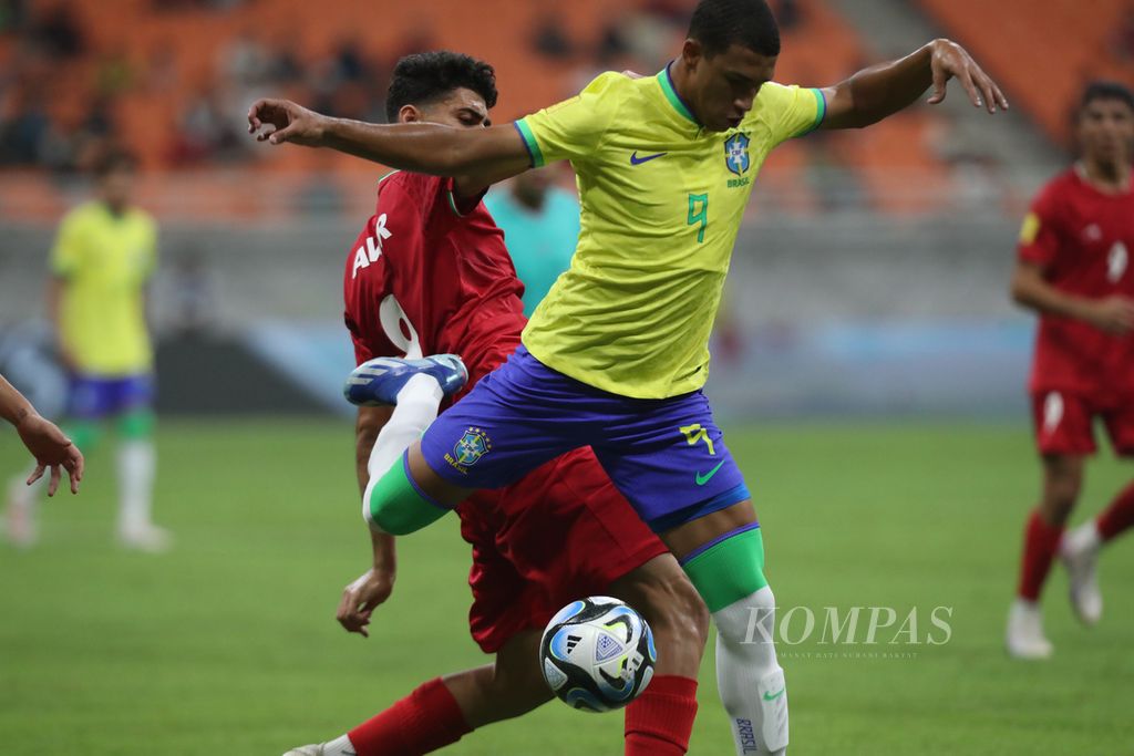 Pemain Brasil, Kaua Elias (depan), berebut bola dengan pemain Iran, Yaghoob Barajeh, di Grup C Piala Dunia U-17 2023 di Stadion Internasional Jakarta (JIS), Sabtu (11/11/2023). Iran menang 3-2 atas Brasil. 