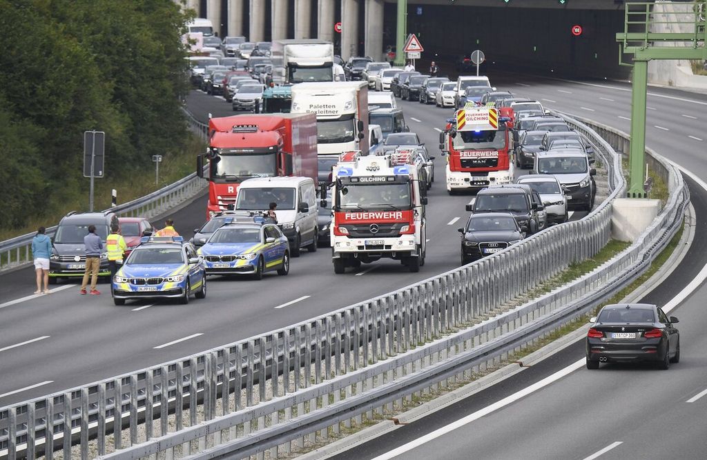 Lalu lintas jalan raya di dekat Munich ditutup sementara setelah aktivis perubahan iklim Extinction Rebellion menggelar aksi di atas jembatan penyeberangan untuk menghalangi akses menuju ke ajang International Motor Show (IAA) yang diadakan di Munich, Jerman, Selasa (7/9/2021). 